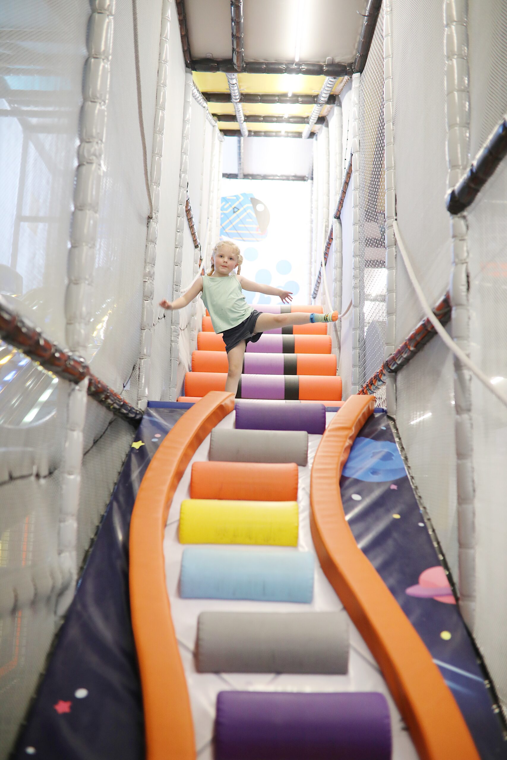 A spacious indoor play area filled with colorful balloons and a prominent sign.