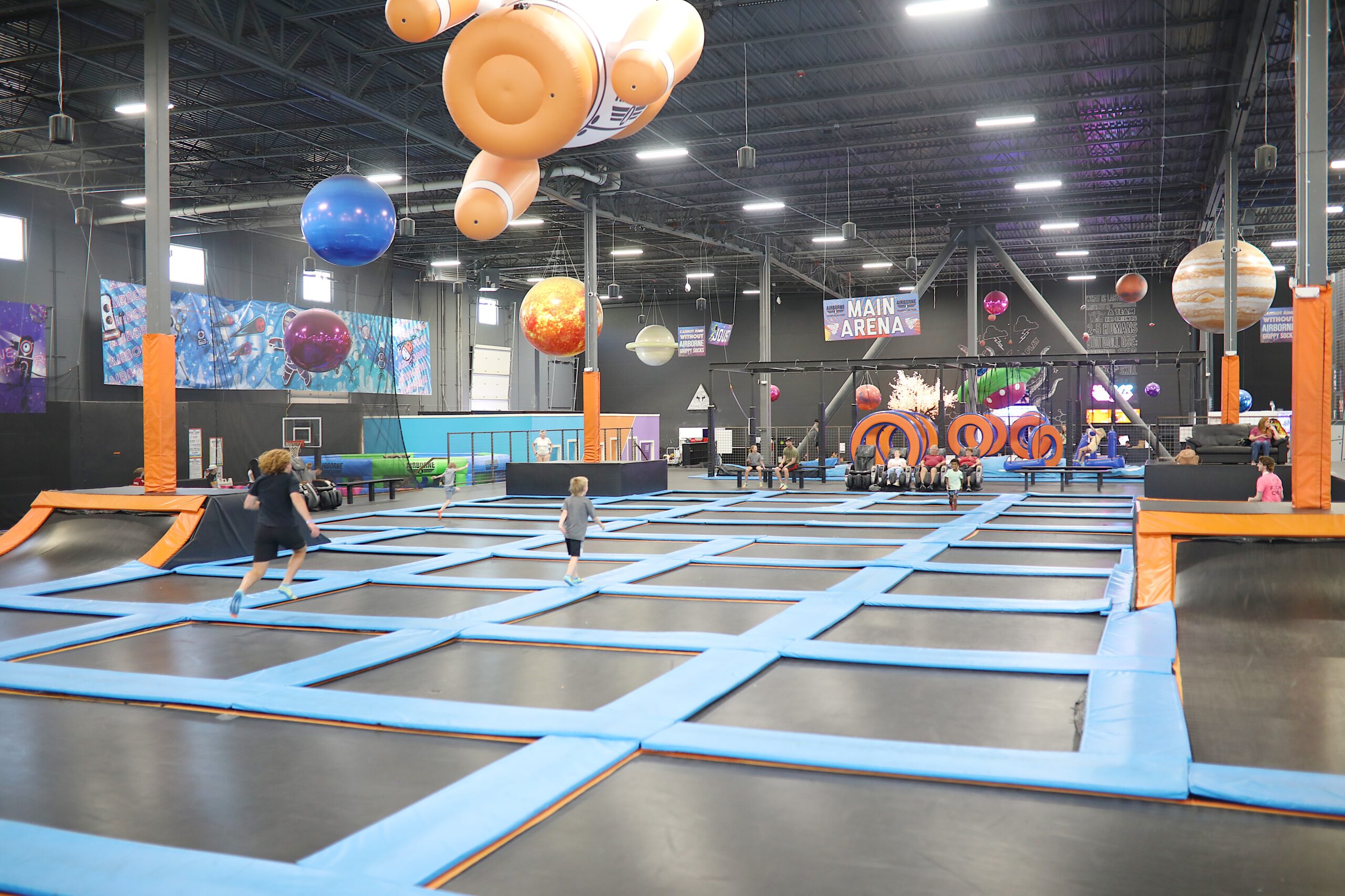 An expansive indoor trampoline park featuring a sign for the main arena.