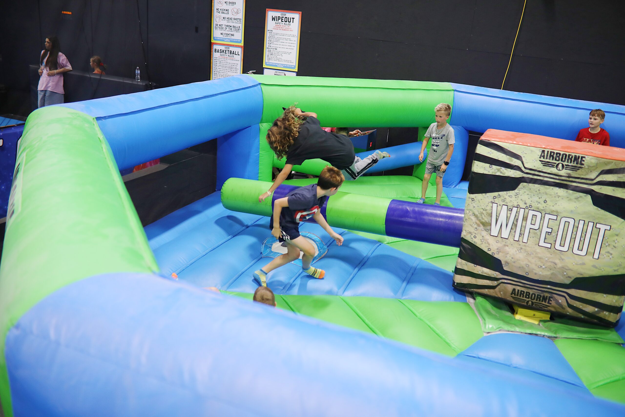 Friends enjoying inflatable obstacle course together.