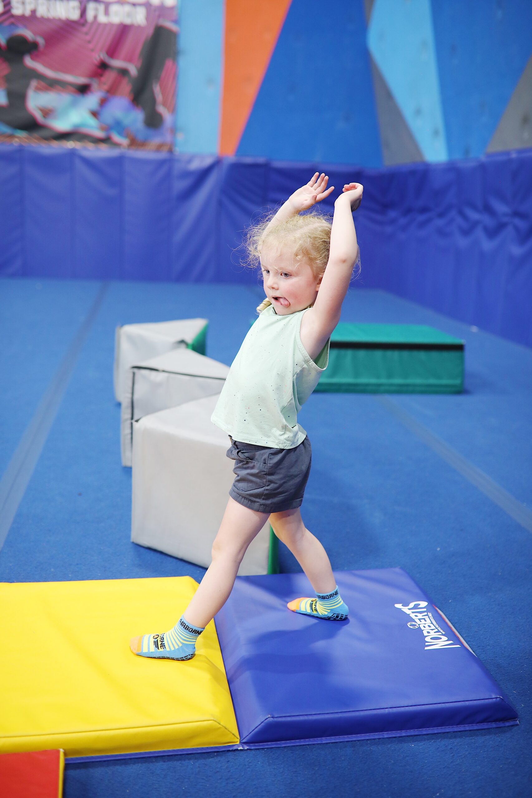 Indoor trampoline park with a large orange rocket.